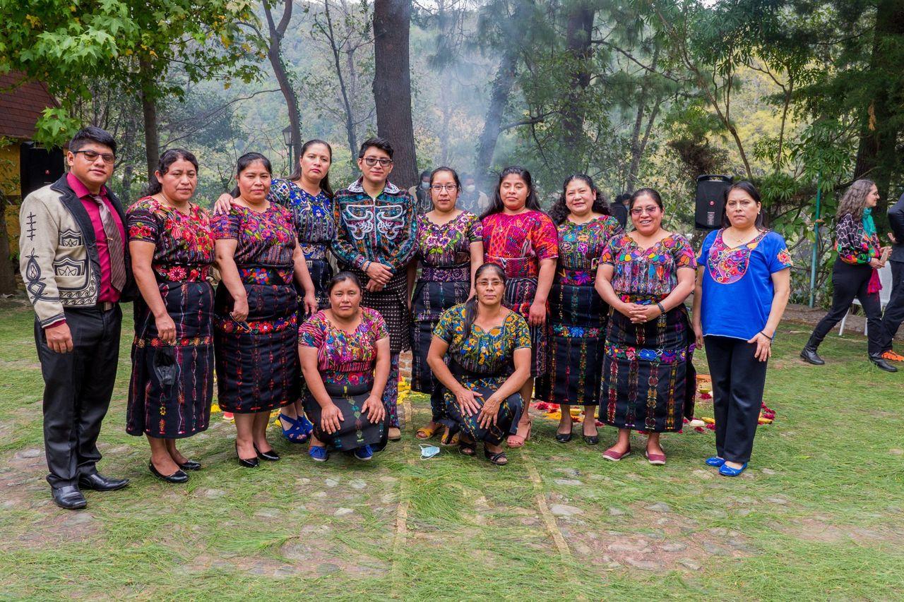 Das Team der Stiftung und Frauen in Maya-Tracht stehen gemeinsam im Garten